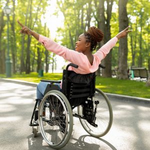 Young,Handicapped,Black,Woman,In,Wheelchair,On,Walk,At,Green